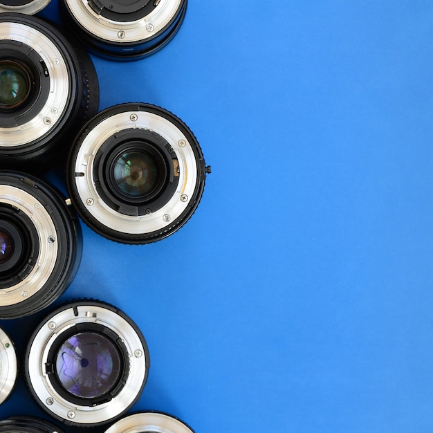 Diversas lentes fotográficas encontram-se em um fundo azul brilhante. espaço para texto