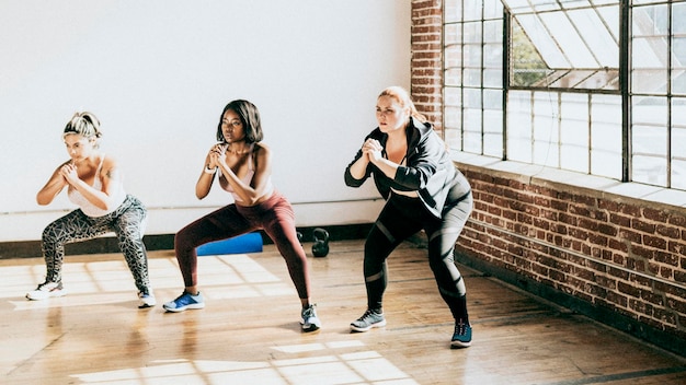 Diversas mujeres activas haciendo sentadillas.