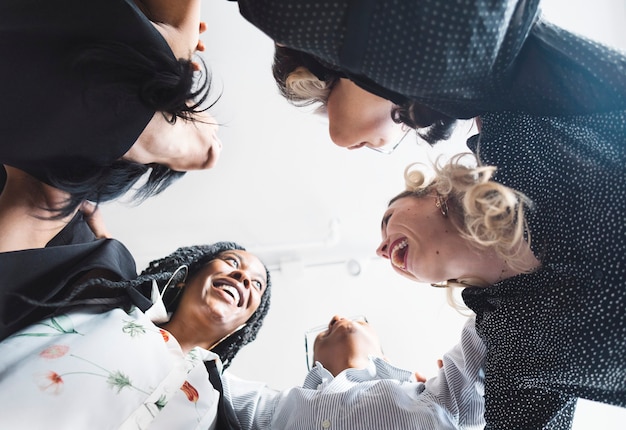 Diversas mujeres empresarias en una postura de abrazo de grupo