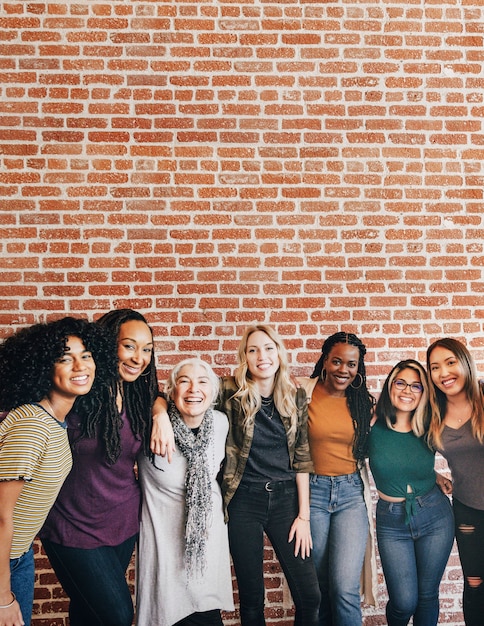 Diversas mujeres juntas por una pared de ladrillos