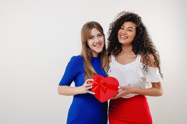 Diversas novias con caja de regalo de San Valentín en forma de corazón aislado