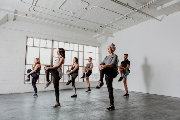 Diversas personas estirando sus rodillas en una clase de yoga