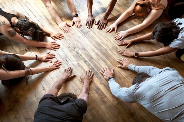 Diversas personas haciendo una pose de Balasana en círculo