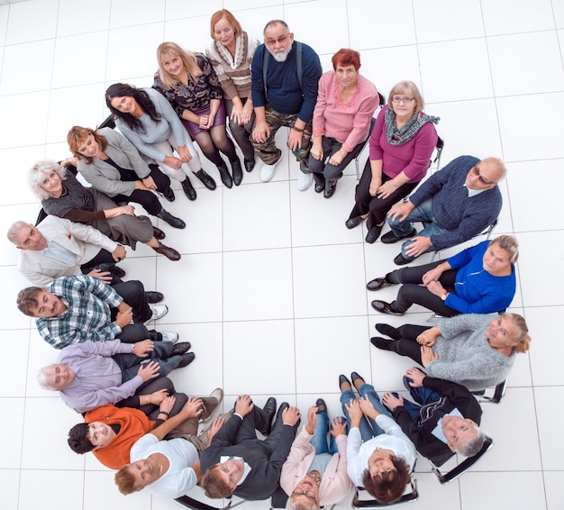 Foto diversas personas maduras sentadas en círculo y mostrando su unidad