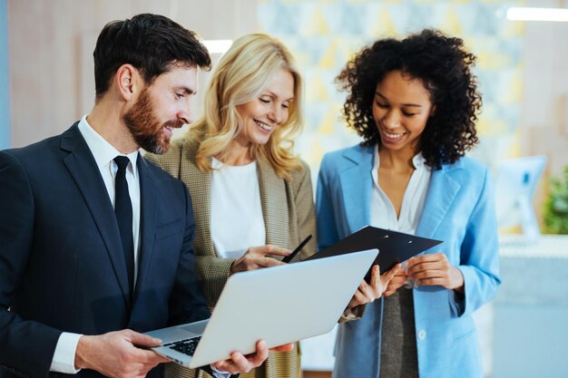 Diversas personas que trabajan en la computadora portátil en línea en los conceptos de la sala de reuniones sobre negocios y tecnología