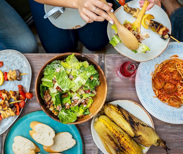 Foto diversas pessoas comendo comida juntos