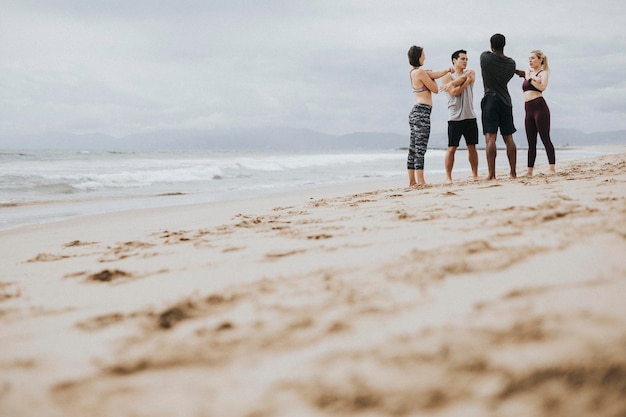 Foto diverse freunde, die sich am strand ausstrecken