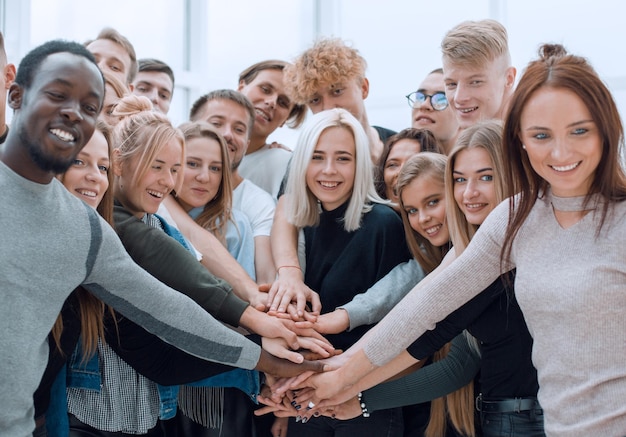 Diverse junge Leute, die ihre Hände zusammenlegen