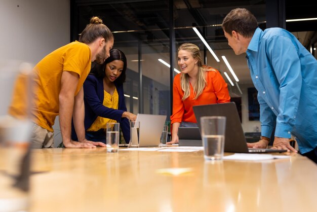 Diverse kreative Kollegen in Diskussionen, Brainstorming mit Laptops und Notizen im Besprechungsraum. Gelegentliches Büro, Brainstorming, Business, Teamarbeit, Business und kreative Arbeit, unverändert.