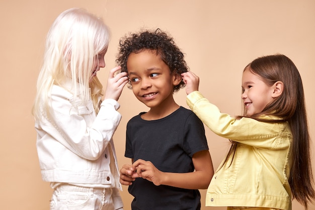 Foto diverse lächelnde positive kinder, die glücklich zusammen aufwerfen