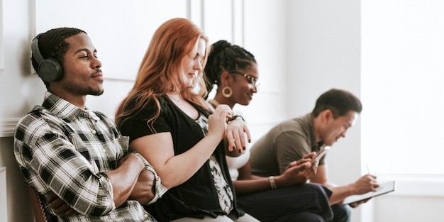 Diverse Menschen, die digitale Geräte verwenden