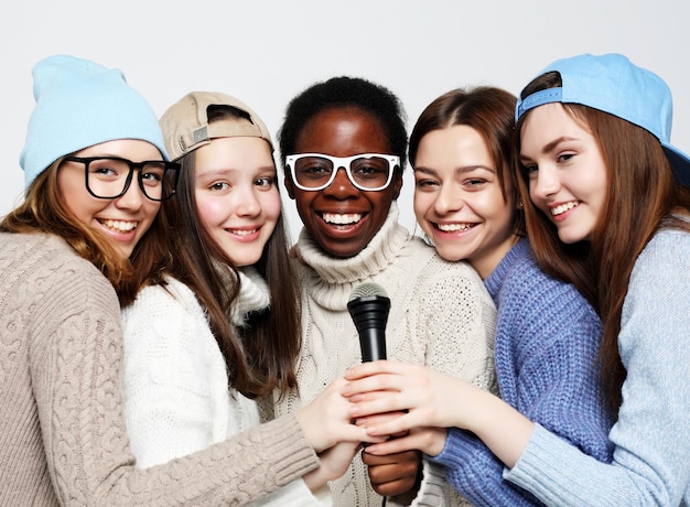 Diverse Multi-Nation-Mädchen gruppieren Teenager-Freunde, die fröhlich Spaß mit dem Mikrofon haben