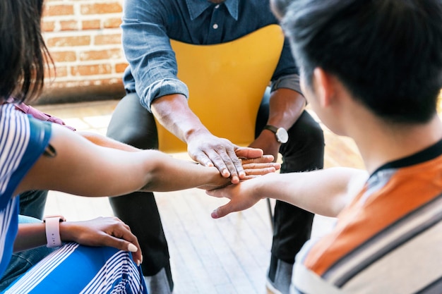 Diverse Teams, die Hände in der Mitte stapeln