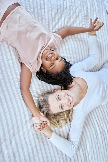 Diversidad amor y familia juntos en el dormitorio para tiempo de calidad o apoyo para el cuidado de la adopción y felicidad Familia feliz diverso retrato de madre e hija en la cama para relajar la unión tranquila y divertida