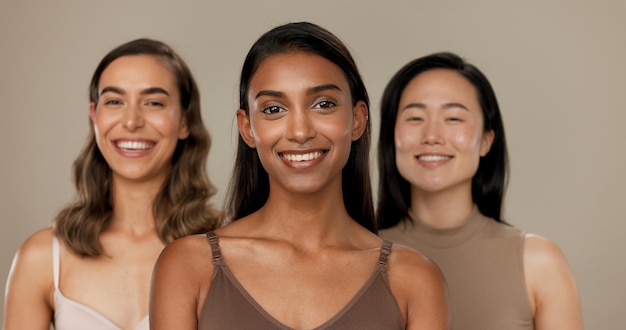 Foto diversidad de belleza o sonrisa de mujeres amigas en el estudio para la inclusión de retratos o bienestar rostro de personas felices en un fondo neutral como diferente cuidado de la piel dermatología brillo o comparación cosmética