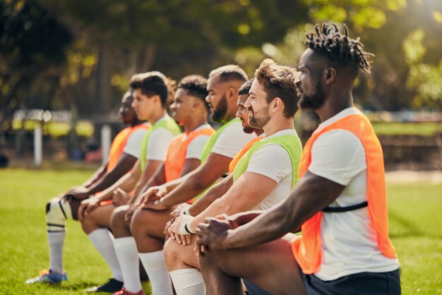 Diversidad deportiva de rugby y hombres entrenando al aire libre en un campo de hierba con un equipo de rodillas Grupo de atletas juntos para hacer ejercicio físico y entrenar para un club deportivo profesional y un fuerte trabajo en equipo