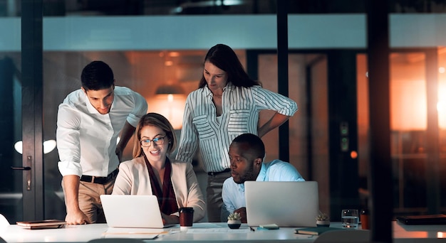 Diversidad del equipo de colaboración y oficina por la noche para estrategia de plazo y explicación con computadora portátil Grupo de líderes femeninas y taller para aprender crecimiento y desarrollo en el lugar de trabajo por la noche
