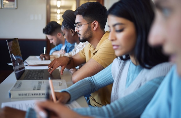 Diversidad de estudiantes y libros de computadoras portátiles en lecciones de aula y estudio de biblioteca para investigación educativa y aprendizaje Grupo escolar universitario y tecnología universitaria en campus de becas globales