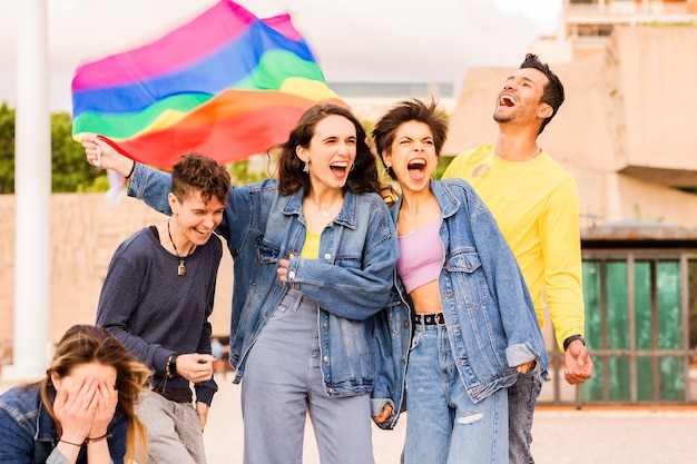 Diversidad multiétnica grupo lgbtq con amigos de la bandera del arco iris para la expresión de género y el orgullo de identidad ...