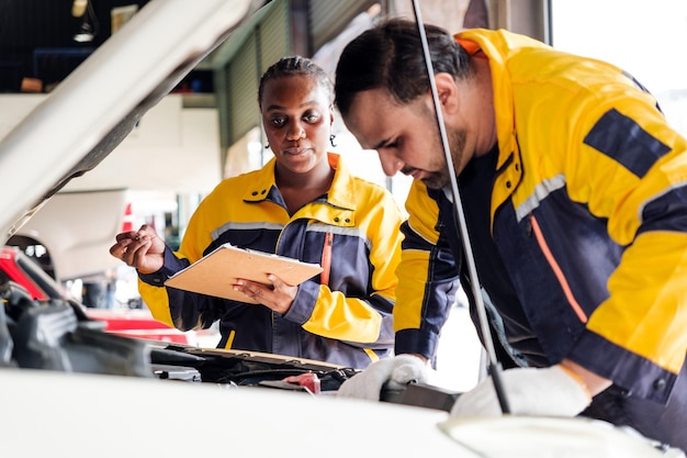 Diversidad trabajo en equipo mecánico un hombre indio y una mujer africana en uniformes amarillos y azules