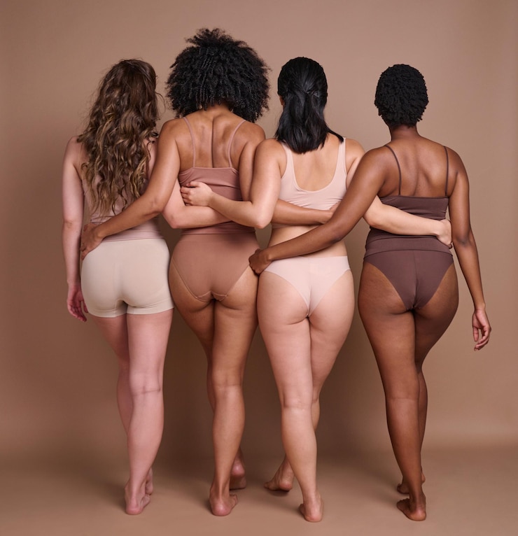 Foto diversidade de costas e positividade corporal com amigas no estúdio em um fundo marrom para uma confiança natural atrás normais e inclusão com um grupo de amigas posando para promover pessoas reais