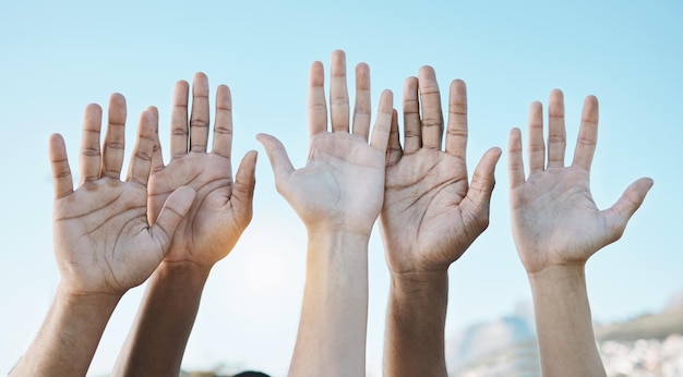 Diversidade palma das mãos e grupo para celebração ao ar livre ou formação de equipe juntos para apoio, motivação e solidariedade Pergunta de mão levantada ou comunidade de pessoas no fundo do céu azul