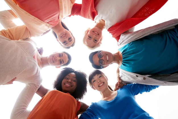 diversidade, raça, etnia e conceito de pessoas - grupo internacional de mulheres diferentes felizes e sorridente em círculo e abraçando sobre branco