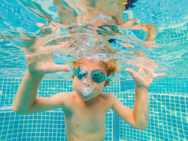 Diversión bajo el agua para niños pequeños en la piscina con gafas Diversión de vacaciones de verano