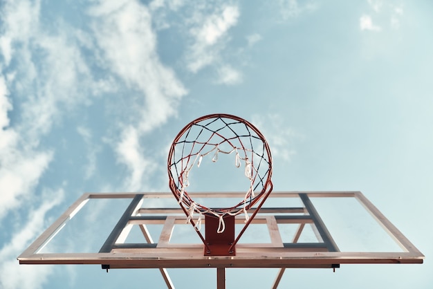 Diversión al aire libre. Disparo de aro de baloncesto con el cielo de fondo al aire libre