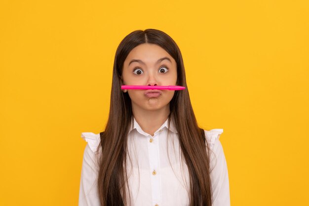 Diversión en la escuela. Muchacha divertida mantenga la pluma como bigote. Educación escolar. De vuelta a la escuela. 1 de septiembre. Día del conocimiento.