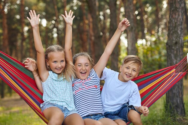 Diversión en el jardín. niños encantadores jugando en una hamaca de colores