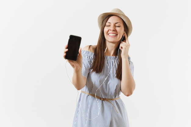 Diversión joven mujer feliz escuchando música en auriculares en el teléfono móvil con pantalla vacía negra en blanco aislada sobre fondo blanco. Gente, emociones sinceras, concepto de estilo de vida. Área de publicidad. Copia espacio