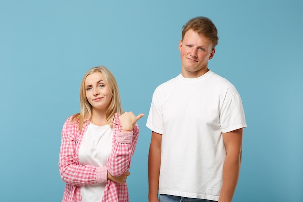 Diversión joven pareja dos amigos chico chica en blanco rosa diseño en blanco vacío camisetas posando