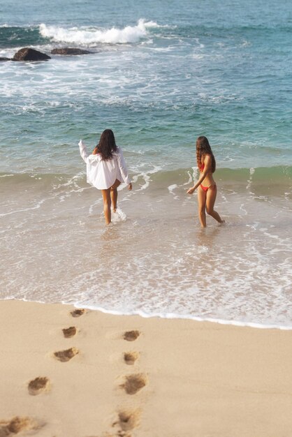 Diversión en la playa de mujeres en bikini durante las vacaciones de verano juntas