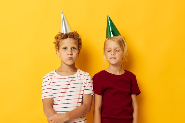 Diversión de vacaciones de niños alegres con gorras en la cabeza fondo aislado