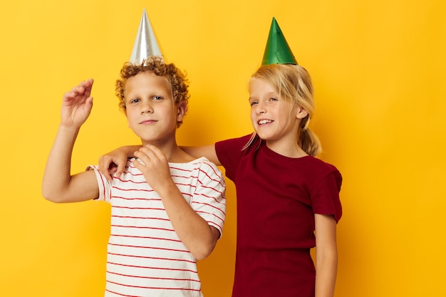 Diversión de vacaciones para niños pequeños con gorras en la cabeza fondo amarillo