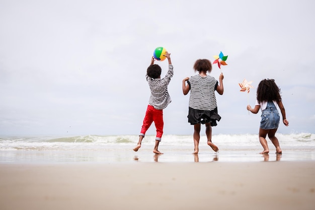 Diversity-Gruppe afroamerikanischer Kinder spielt an einem tropischen Strand Ethnisch vielfältiges Konzept