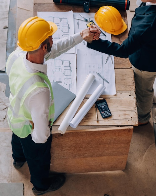 Diverso equipo de especialistas utiliza tabletas en el sitio de construcción Proyecto de construcción de bienes raíces con ingeniero civil arquitecto inversor de negocios y trabajador general discutiendo los detalles del plan