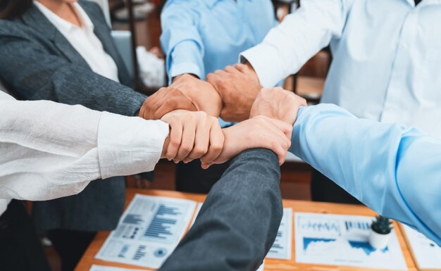 Diverso equipo de trabajadores oficiales toman la mano en círculo en la oficina corporativa Concord