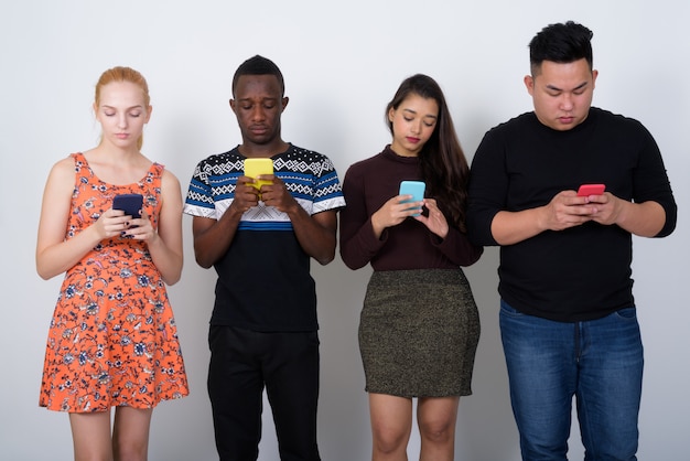 Foto diverso grupo de amigos multiétnicos usando móviles