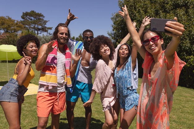 Diverso grupo de amigos tomando selfie en una fiesta en la piscina. Pasar el rato y relajarse al aire libre en verano.