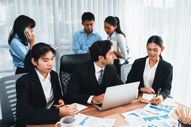 Diverso grupo de equipo de analistas de negocios analizando datos financieros informe papel en la mesa de la oficina Tabla y tablero de gráficos por análisis de inteligencia de negocios para la planificación estratégica de marketing Meticuloso