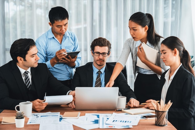 Diverso grupo de equipo de analistas de negocios analizando el informe de datos financieros en la mesa de la oficina Tabla y tablero de control de gráficos por análisis de inteligencia de negocios para la planificación estratégica de marketing Meticuloso