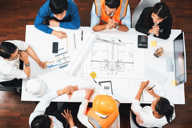 Diverso grupo de ingenieros civiles y clientes trabajando en el arquitecto Prudent