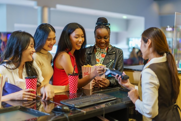 Diverso grupo de mujeres usando tarjetas de crédito en el cine