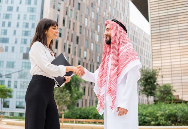 Diverso hombre y mujer dándose la mano durante la reunión