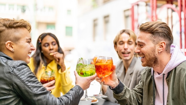 Diversos amigos brindando con bebidas coloridas sin alcohol, personas lgbt divirtiéndose después del desfile del orgullo gay