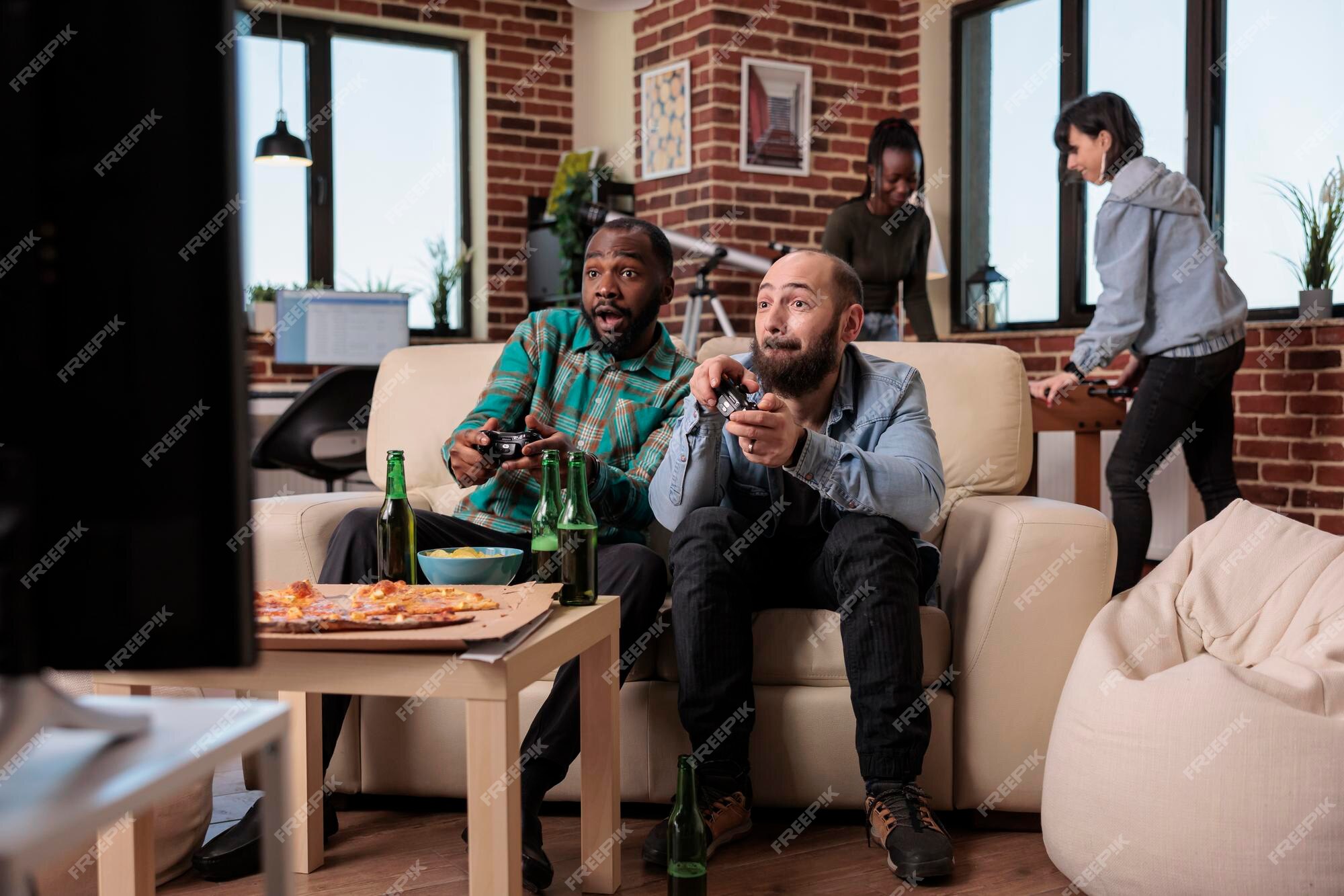 Pessoas alegres se divertindo com jogos de videogame, usando console de tv  e competição de jogos online na televisão. jogando desafio no hangout com  os amigos, bebendo álcool em casa. tiro de tripé.