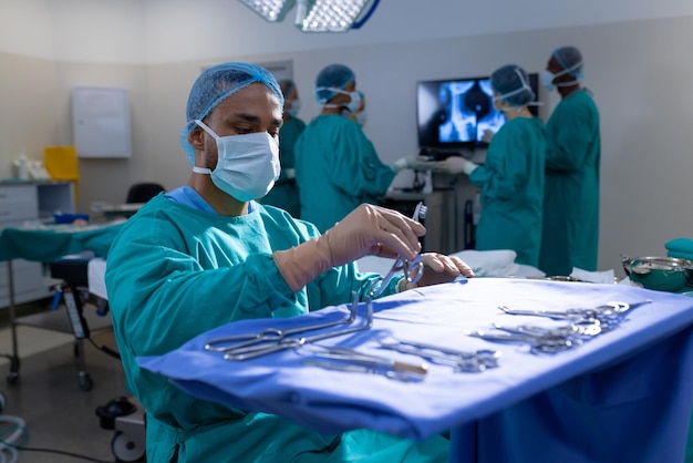 Foto diversos cirurgiões vestindo batas cirúrgicas operando pacientes na sala de cirurgia do hospital