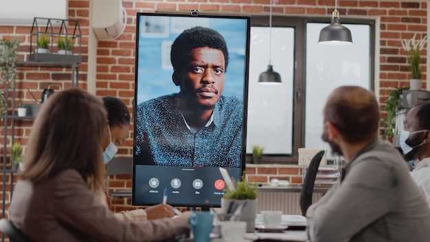 Diversos colegas de trabalho conversando com o homem em videoconferência online, discutindo em videoconferência remota. Empresários usando videoconferência para telecomunicações durante a pandemia de covid 19.